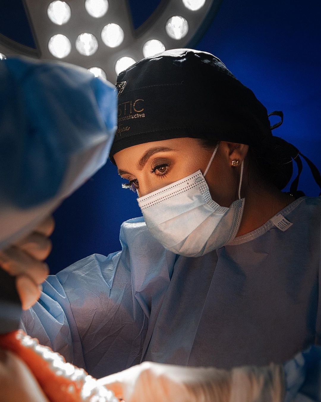 Dr. Nicole Echeverry in surgical cap and mask, concentrating during an operation